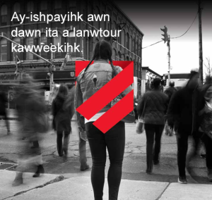 A person with a backpack stands still on a city street as blurred pedestrians walk by; a red graphic with three diagonal lines is overlaid on the person. Text in an Indigenous language appears at the top.